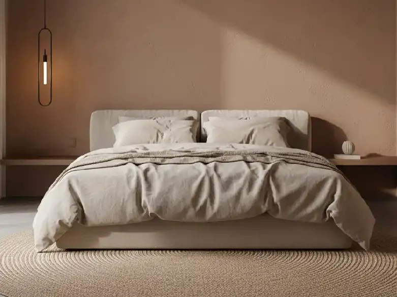 Minimalist modern bedroom with a large, comfortable bed with light-colored bedding. It has a round braided jute rug on the floor. A modern black pendant light hangs on the left. The wall has a warm terracotta color with a subtle texture and has soft sunlight casting a shadow across it.